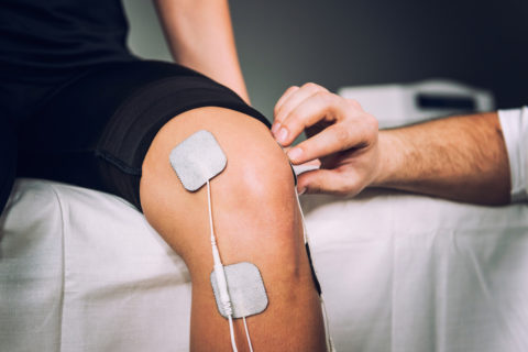 Man receiving e-stim therapy for knee pain.